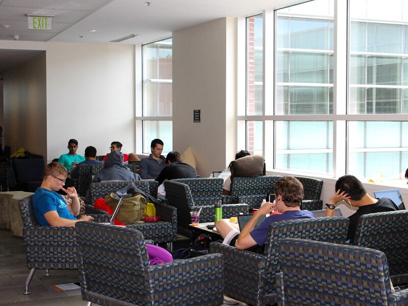 Students on armchairs with laptops at a hackathon